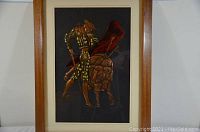 Full view of framed copper art showing a matador posing with a bull on black background.