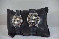 Photo of his and hers Roots wristwatches displayed on a black perforated cushion showing the watch faces.