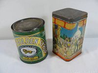 Two vintage tins displayed side by side on a white surface with neutral background.