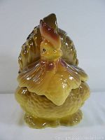Front view of the vintage ceramic chicken cookie jar showing detailed sculpting and coloring.