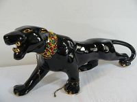 Full side view of glossy black panther figurine with jeweled collar and gold accents.