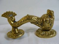 Photo showing the brass serpent door knocker from the side profile against a plain backdrop.