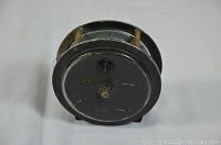 Side view showing the reel spool and metal frame housing fishing line