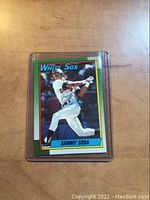 Front of 1990 Topps Sammy Sosa rookie card showing player batting in White Sox uniform