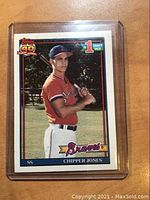 Front photo of 1991 Topps Chipper Jones rookie card showing player holding bat in Braves uniform with 'Topps 40' and '1st Draft Pick' logos.