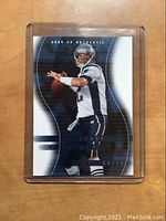 Front of 2004 Upper Deck SP Authentic Tom Brady football card showing image of Brady in Patriots uniform and serial number 061/125.