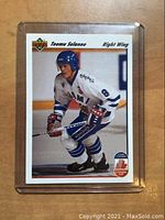 Front side of 1991 Upper Deck Teemu Selanne hockey rookie card showing player skating in white and blue uniform.