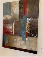 Close-up photo showing textures and color details including gold metallic accents, red and blue color blocks on the canvas framed with wood.