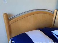 Headboard of the Young American wooden bed with light wood and silver metal accent.