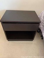 Top view of one Bassett nightstand showing the single drawer and flat top surface.