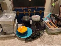 Overall view of assorted serving plates, bowls, glass dishes, aluminum trays and BBQ utensils