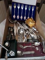 Photo showing various loose silver plated spoons, forks, ladle, and serving utensils including 2 Gerber baby spoons