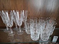 Photo showing 5 Waterford crystal stemware glasses with detailed cut pattern and 8 tumblers grouped behind