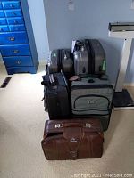 All five suitcases grouped in room next to scale and dresser