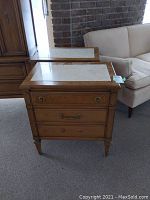 Front angled view of the first night table showing wood finish, drawers, and stone top.