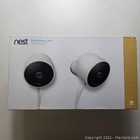 Retail box for Nest Cam Outdoor 2-pack showing front images of two white cameras and Nest logo