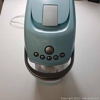 Front top view showing control buttons and part of water bottle attached in the sparkling water maker.