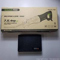Galax Pro reciprocating saw and Tacklife hole saw kit box with closed black carrying case resting on a white surface.