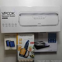 Photo showing boxed VPCOK Vacuum Sealer QH-S12, ThermoPro Indoor Humidity & Temperature Monitor TP-55-2, Vegetable Chopper, and Digital Kitchen Scale