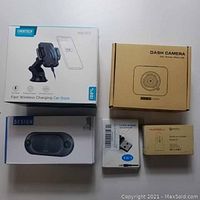 Photo of all five boxed items arranged flat: Choetech car dock, dash camera, Design Bluetooth speaker, wireless audio transmitter/receiver, Hussell quick car charger