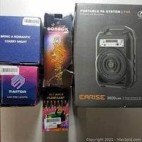 Five boxed party items: Earise portable PA system, Bonaok karaoke mic, Sky disco flash lamp, Saitor LED par lights, romantic starry night remote night projector box.