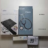 Photo of full lot boxes - heating pad, stethoscope, posture corrector, thermometer, blood pressure monitor