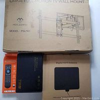 Closed box of Perlesmith full motion TV wall mount with the black TV box, smart remote control box, and flat digital HDTV antenna box arranged below