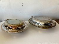 Two vintage silver plate covered serving dishes with lids, viewed from above showing top and side details