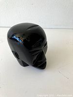 Front angle of the vintage black glass head figurine showing stylized facial features with glossy finish.