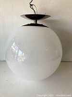 Side view showing white glass globe and metal mounting details.