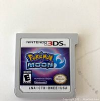 Front of Nintendo 3DS Pokémon Moon cartridge with label showing game title and branding.