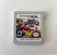 Front view of Nintendo 3DS Super Smash Bros game cartridge with label showing characters and branding.