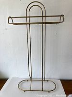 Front view of brass plated blanket/towel stand showing full structure including base and hanging bars