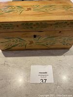 Top view of antique pine box showing green leafy and brown floral stenciled design on lid.