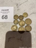 Nine French Franc coins arranged on a surface with auction lot number 68 visible, showing the varying sizes and wear of the coins.