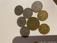 Eight Moroccan coins on a white surface showing detailed obverse and reverse with star and inscription designs.