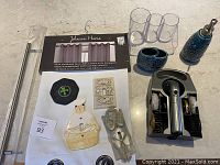 Photo of various home decor and bathroom items including curtain panel packaging, cabinet handle, shoe polish kit components, lucite organizer, turquoise ceramic bathroom accessories, and decorative light switches.