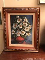 Front view of framed original floral painting showing white daisies in red vase, signature visible.