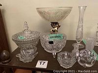 Photo showing the overall lot of lead crystal and cut glass items including bowls with feet, bowl with lid, blown glass mini vase, and smaller cut glass pieces.