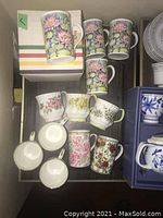 Photo showing pastel floral mugs and assorted floral bone china tea cups and saucers