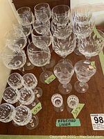 Full lot overview photo showing all sets of stemware arranged side by side with labels indicating quantities and sizes