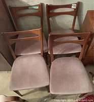 Four chairs grouped against basement wall showing front view of upholstered seats and backrests