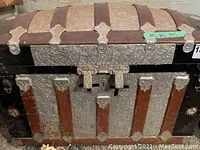 Front view of trunk showing embossed metal and wood slats