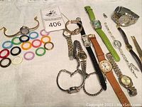Collection of assorted watches displayed on white surface with various colored plastic bezel rings, some watches with metal link and leather bands.