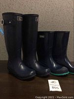 Two pairs of tall women's rain boots displayed side by side. G.H. Bass & Co on left, LaCrosse on right.