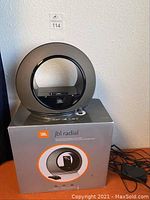 JBL Radial loudspeaker dock standing on its original box, showing the circular design and iPod dock in the center