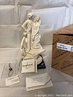 Front view of porcelain bride and groom figurine with original box and paperwork.