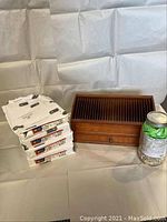 Photo showing stacks of NCR printer paper packages next to a wooden desk organizer with vertical slots and a compartment drawer.