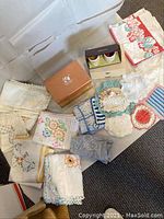 All linens, two china sets in boxes, and flatware box arranged on floor showing full lot