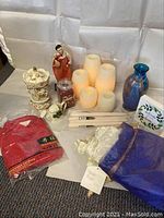 Photo of all items including candles, vase, figurines, shirt, and bedding